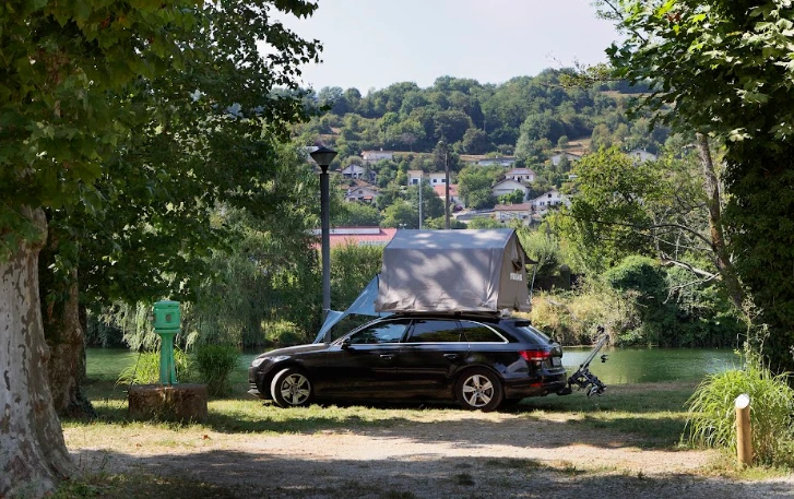 Emplacement pour voiture avec une tente de toit en bord de rivière