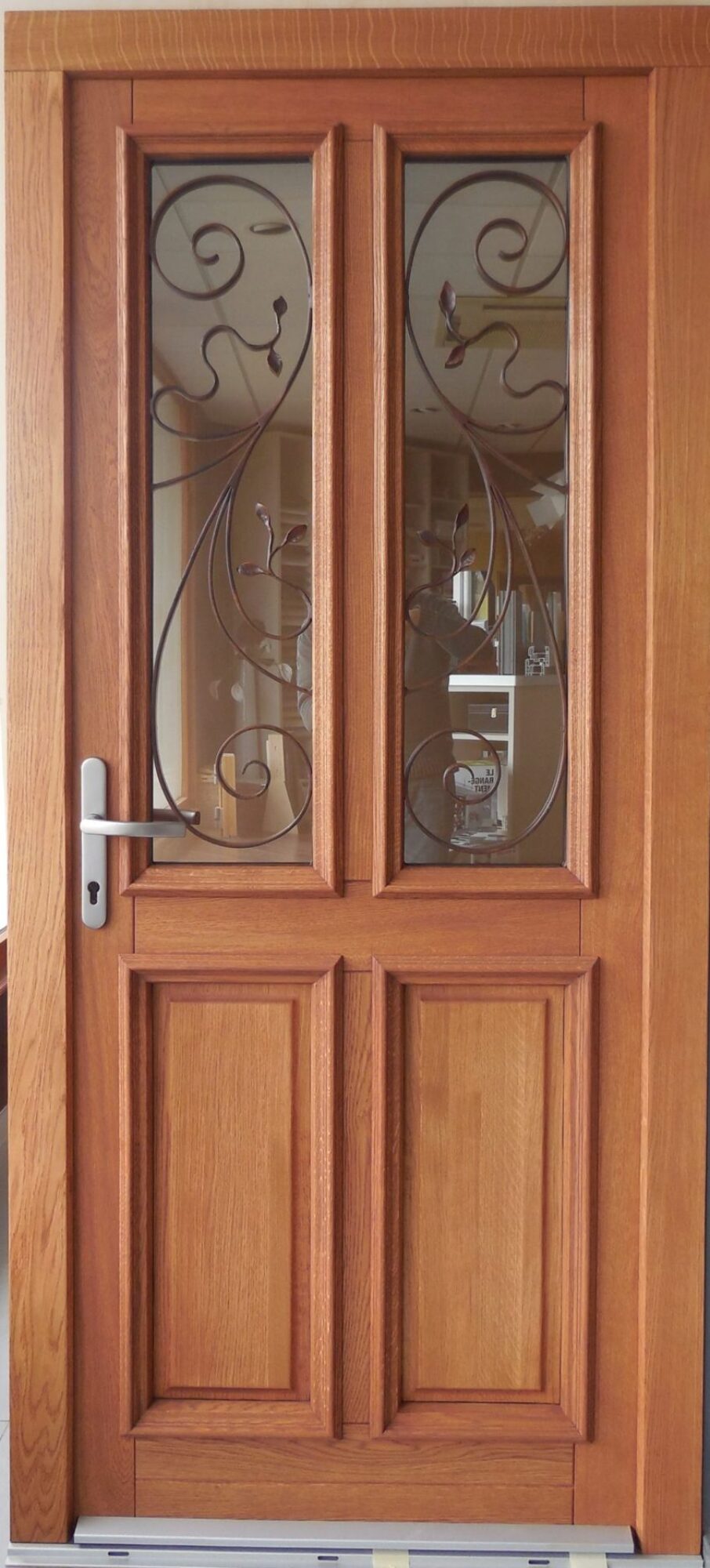 Porte d'entrée en bois avec grille en fer forgée