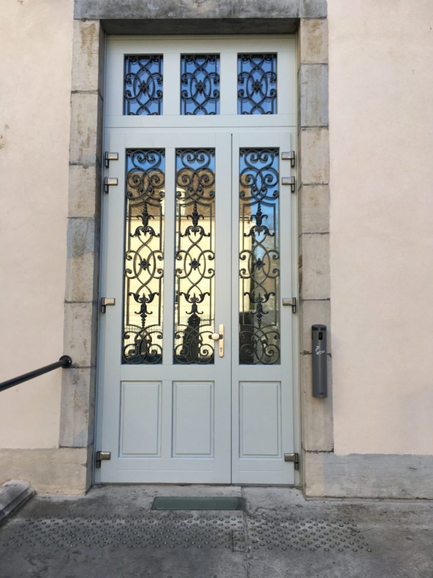 Porte d'entrée en bois avec grille en fer forgée