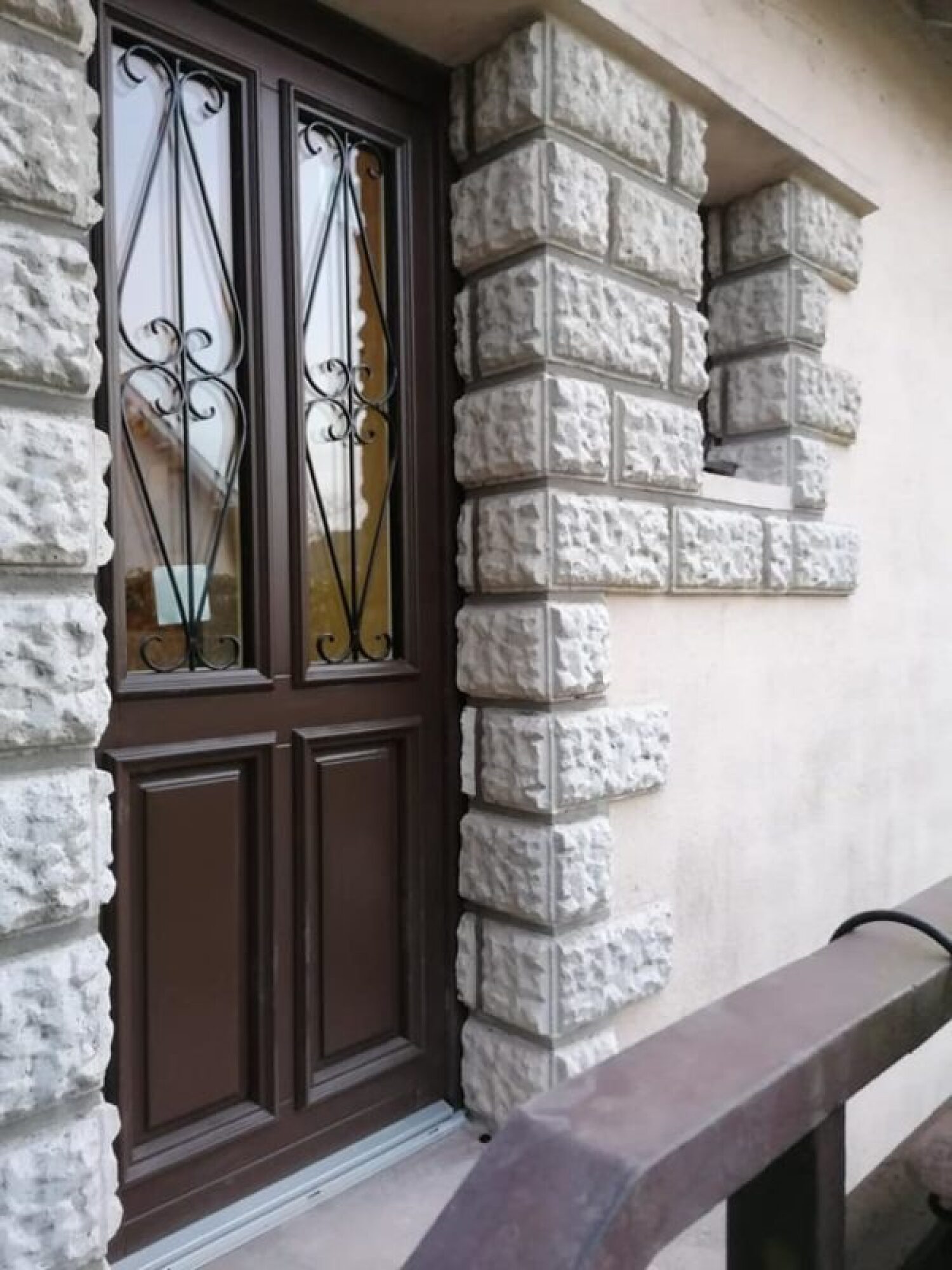 Porte d'entrée en bois avec grille en fer forgée